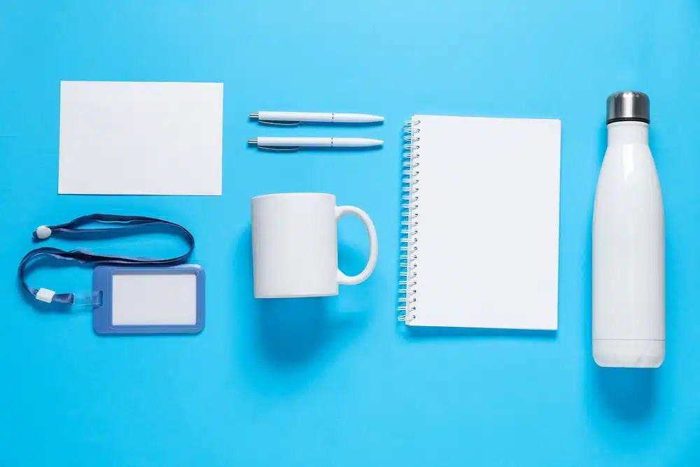 Different blank items for branding on light blue background, flat lay.